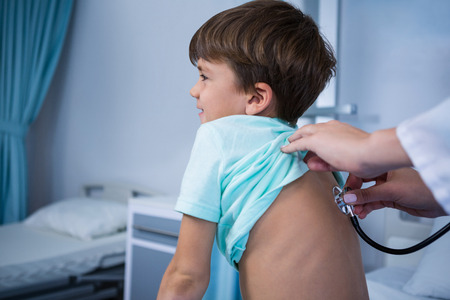 Doctor examining patient in ward at hospitalの写真素材
