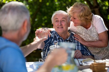 Senior couples having breakfast in garden on a sunny day