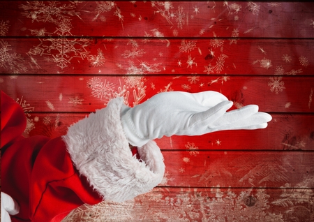 Santa claus pretending to be hold against red wooden backgroundの写真素材