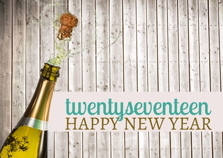 2017 happy new year wishes with opened champagne bottle cork popping against wooden background