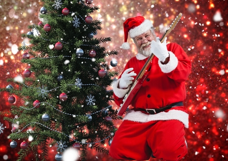 Santa playing electric guitar against digitally generated blue backgroundの写真素材