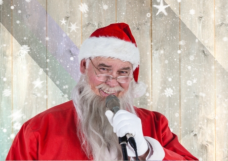 Portrait of santa singing christmas song on microphone against wooden backgroundの写真素材