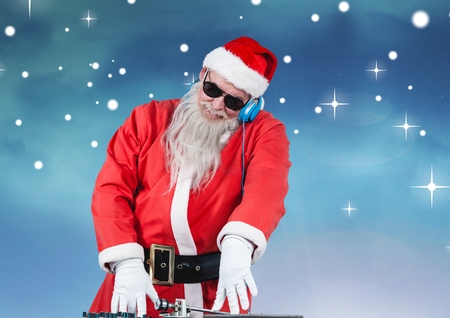 Santa in sunglasses playing dj against digitally generated backgroundの写真素材