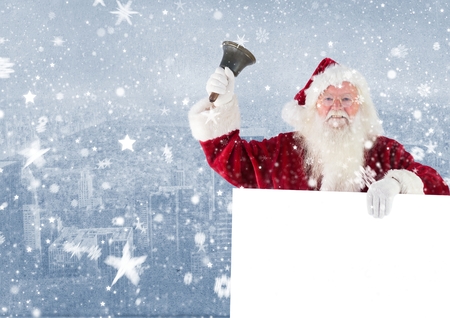 Santa claus holding a blank placard and bell against digitally generated city backgroundの写真素材