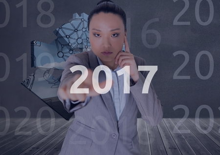 Portrait of business woman in digitally generated background touching 2017 new year