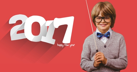 Smiling boy with stick standing next to 2017 message against red background