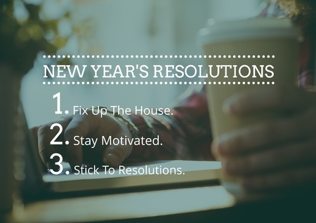 New year resolution goals against hand holding coffee cup in background
