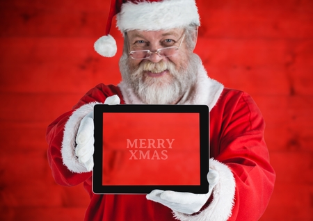 Portrait of santa claus holding a digital tablet with text marry xmassの写真素材