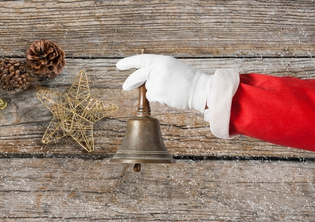 Close-up of hand of santa claus holding christmas bellの写真素材