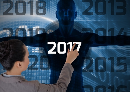 Woman touching 2017 new year on digitally generated human body silhouetteの写真素材