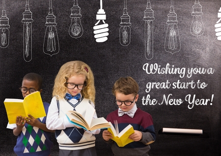 Three children reading books against blackboard with 2017 new year greeting quotesの写真素材