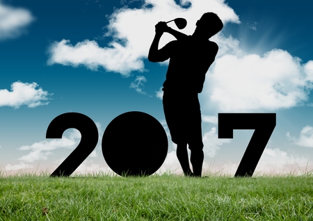 Silhouette of man playing golf forming 2017 new year sign on grassの写真素材