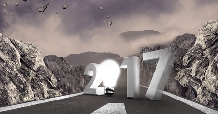 Composite image of 2017 with light bulb against a road between mountainsの写真素材