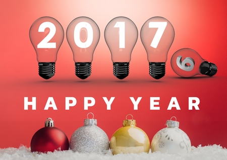 2017 sign inside light bulbs with colorful christmas baubles against red backgroundの写真素材