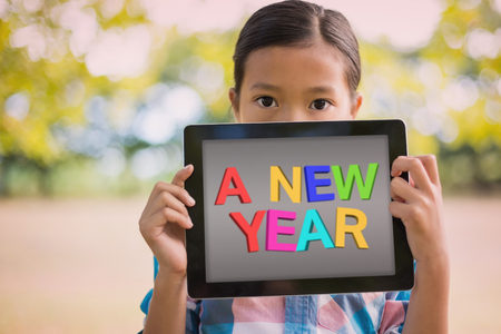 A new year against girl holding digital tablet while standingの写真素材