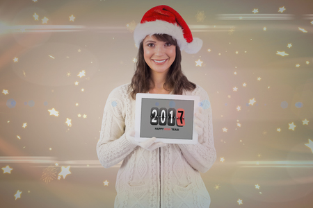 Digital composite of Pretty girl showing tablet with 2017 on itの写真素材
