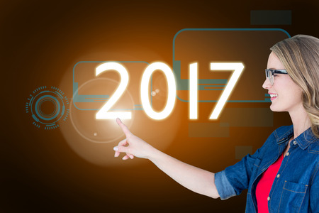 Smiling woman wearing eyeglasses pointing  against orange background with vignette