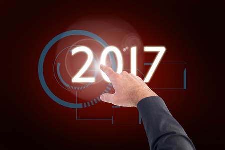 Businessman pointing with his finger against red background with vignetteの写真素材