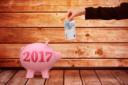 Businesswomans hand holding twenty euro note against a wall
