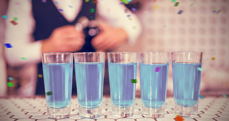 Glasses of blue lagoon drinks on bar counter against flying colours