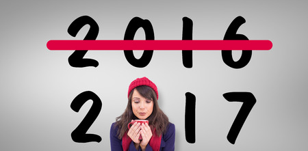 Festive brunette holding a mug against grey vignette