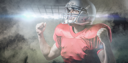 3D American football player cheering with clenched fist against splashing of powder