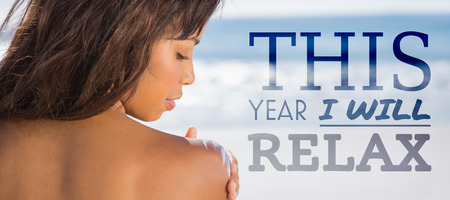 this year i will relax against rear view of woman applying sun cream on her shoulderの写真素材