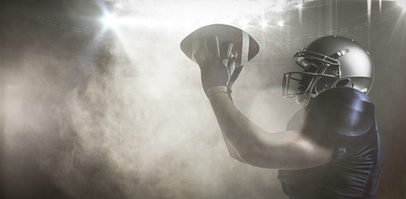 3D American football player catching ball against splashing of yellow color powderの写真素材