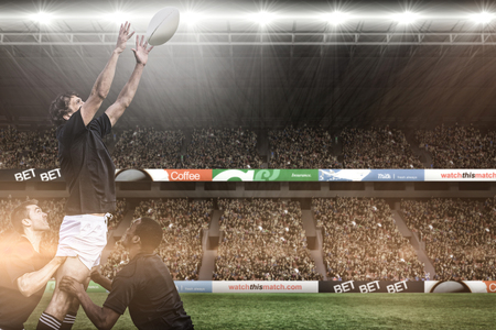3D Rugby fans in arena against rugby players jumping for line outの写真素材