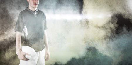 3D Frowning rugby player with arms crossed against splashing of powderの写真素材