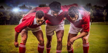 3D Blue and orange sky with clouds against rugby players ready to playの写真素材
