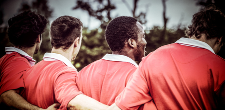 3D Dark blue green background against rugby players standing together before matchの写真素材