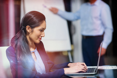 Portrait of businesswoman working on laptop in officeの写真素材