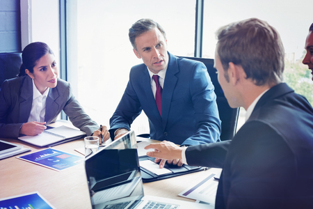 Business people interacting in conference room during meetingの写真素材