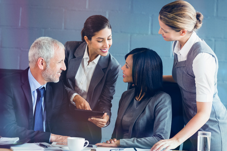 Businesspeople interacting in conference room in officeの写真素材