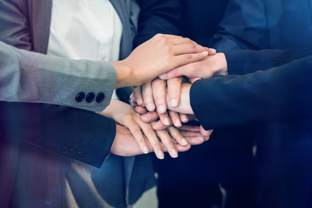 Close-up of businesspeople stacking hands in meeting at office