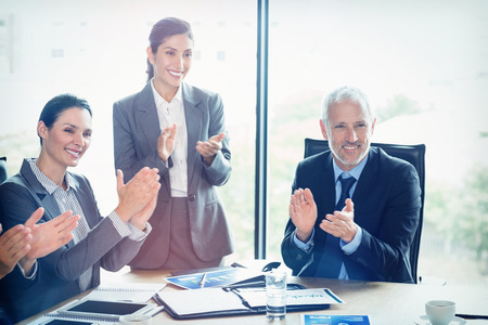 Businesspeople applauding in conference room during meetingの写真素材