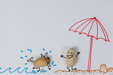 Conceptual image figurine of a dog running towards a happy figurine of a man on the beachの写真素材