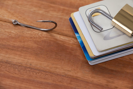 Conceptual image of credit cards bunch, fishing hook and lock on wooden backgroundの写真素材