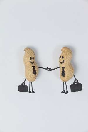 Close-up of figurine of two businessmen shaking hands, conceptual imageの写真素材