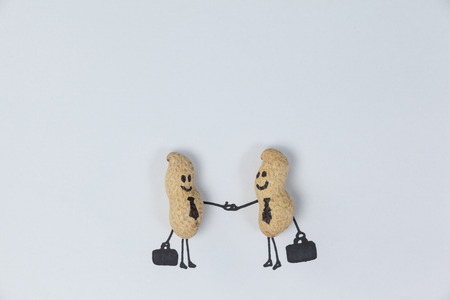 Figurine of two businessmen shaking hands, conceptual imageの写真素材