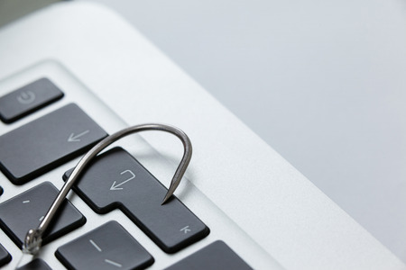 Close-up of fishhook on laptopの写真素材