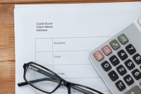 Paper document with calculator and spectacles on wooden backgroundの写真素材