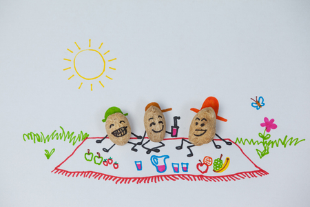Conceptual image of three happy peanut  figurines have picnic on a sunny dayの写真素材