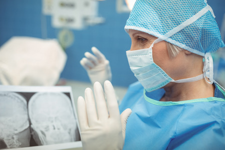 Female surgeon wearing surgical mask in operation theater at hospital