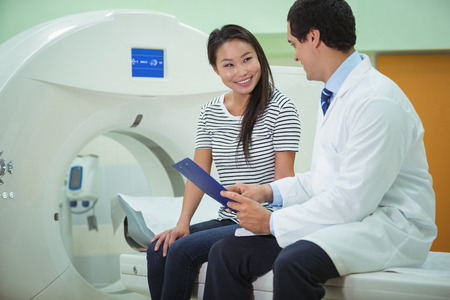 Doctor and patient discussing over clipboard in the hospital