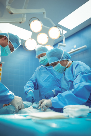Team of surgeons performing operation in operation theater at hospitalの写真素材