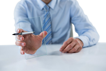 Mid section of businessman holding pen and glass sheetの写真素材