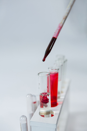 Close-up of blood sample being drop into test tubesの写真素材