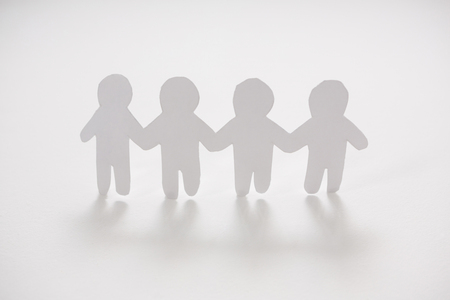 Row of paper cut-out figures on white backgroundの写真素材